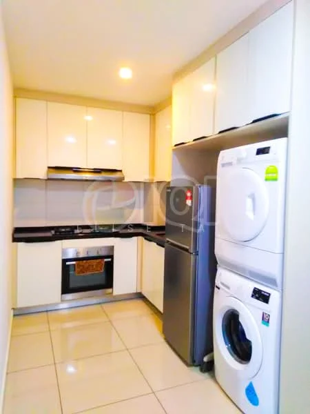 Kitchen features: white glossy cabinetry, black countertop, stainless-steel built-in oven, stainless-steel gas hob, stainless-steel range hood, stainless-steel fridge, front-load washing machine, tumble dryer, recessed LED downlights, cream tiled flooring, grey backsplash, open shelving; style: modern.