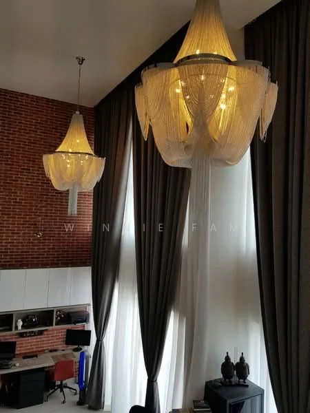 Room features: two large chandeliers with decorative fringe, exposed brick wall, floor-to-ceiling windows, sheer curtains, dark grey drapes, built-in desk area with shelving, dark wood furniture, decorative vases or sculptures; style: modern.