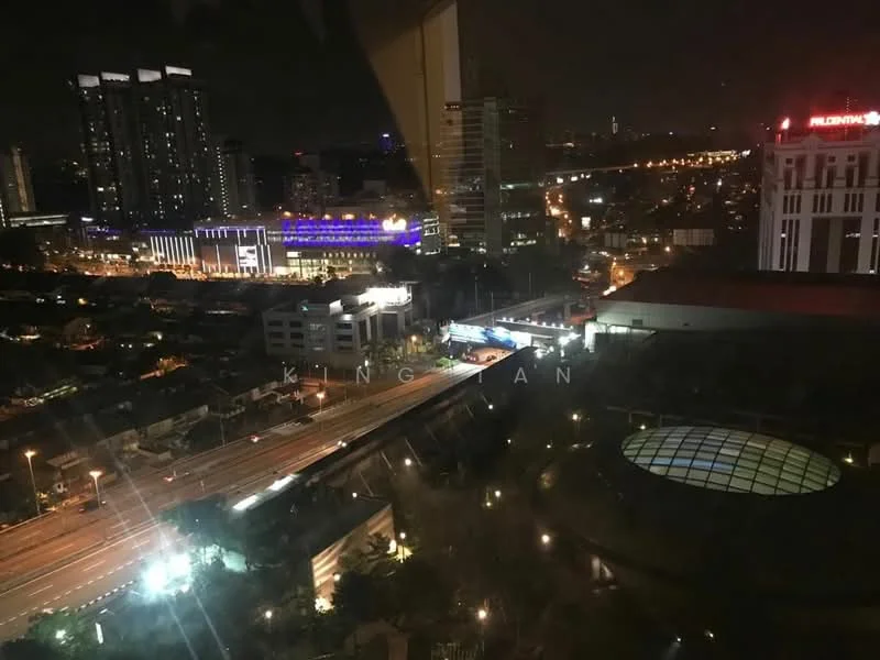 Exterior type: high-rise condominium; features: city skyline view, nighttime lighting, surrounding urban landscape, visible highway, commercial buildings, illuminated structures, parking area, landscaped ground level; style: modern.