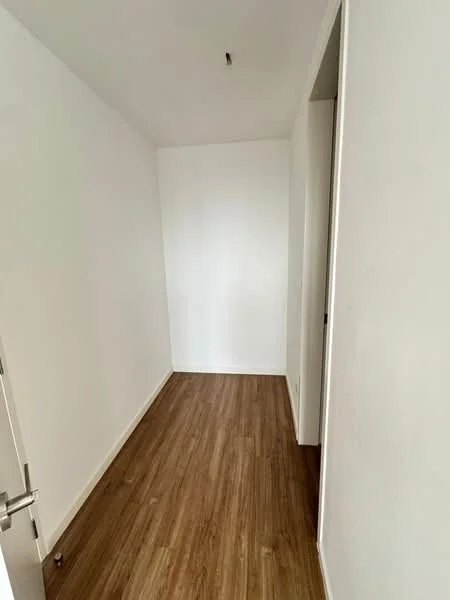 Room features: white painted walls, laminate flooring, single door, ceiling light fixture.