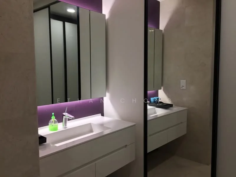 Bathroom features: white vanity with double sinks, chrome basin mixer faucets, large framed mirrors, backlit mirror, purple accent wall, light-colored wall tiles, stone flooring, built-in cabinetry; style: modern.