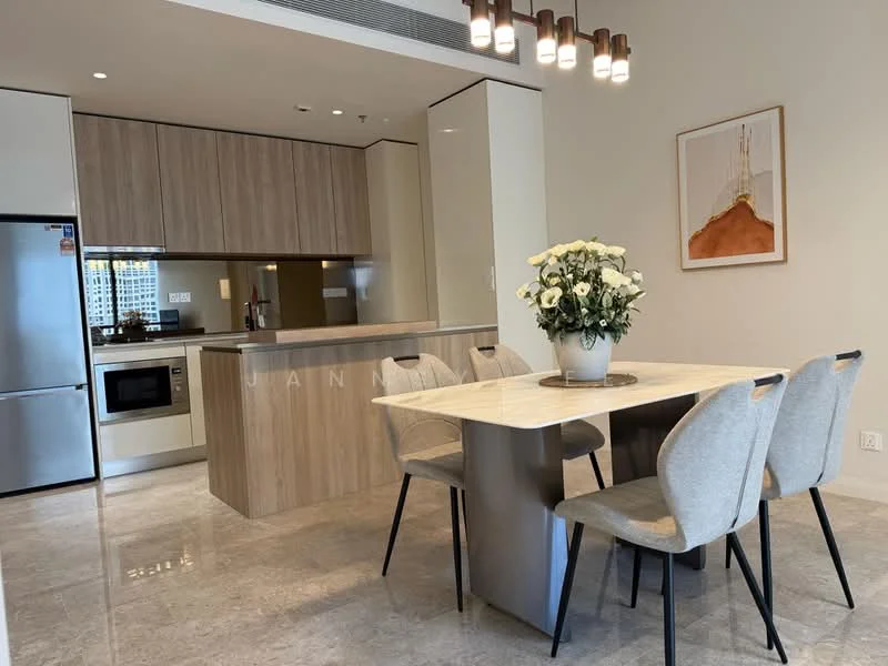 Kitchen features: stainless-steel fridge, built-in oven, freestanding microwave, kitchen island with seating, laminate cabinetry in light wood, quartz countertop, ceramic tile flooring, recessed downlights, pendant lighting above dining table, open-plan layout, dining table with four chairs, decorative vase with flowers, framed artwork on wall; style: modern.