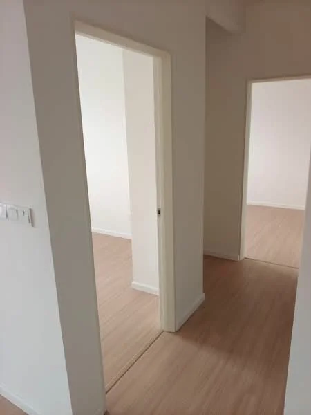 Room features: light wood flooring, white painted walls, door frames, doorway openings.