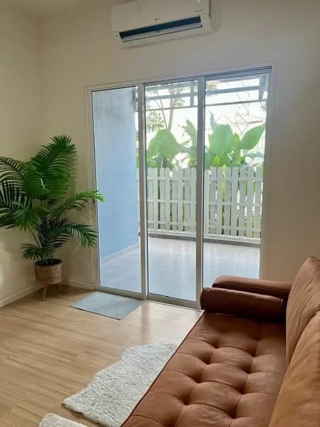 Living features: brown tufted sofa, laminate flooring, floor-to-ceiling sliding glass door, potted plant, sheer curtains, white walls, air conditioning unit, area rug; style: modern; view: garden.