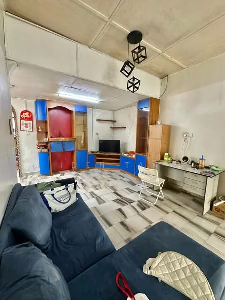 Living features: blue cabinetry, wooden shelving unit, black television, white desk, white folding chair, sofa in dark blue fabric, pendant light fixture, tile flooring with a mixed pattern, wall-mounted electrical outlets, decorative items on desk.