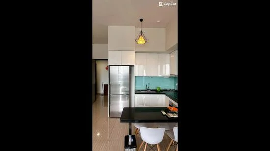 Kitchen features: white glossy cabinetry, stainless-steel fridge, glass backsplash in teal, black countertop, pendant light fixture, four-seater dining table, white dining chairs, built-in oven, gas hob, sink, wall-mounted cabinets, open shelving; style: modern.