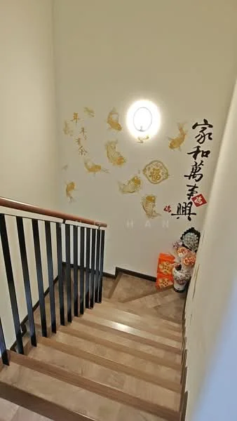 Room features: wooden staircase, light-colored walls, decorative wall art with gold accents, wall-mounted light fixture, dark handrail, laminate flooring, decorative items at the base of the stairs; style: modern.