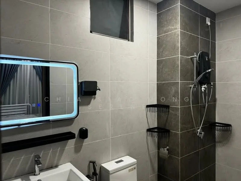 Bathroom features: grey tiled walls, white ceramic sink, chrome basin mixer faucet, one-piece toilet, walk-in shower with glass partition, rain shower head, handheld shower, framed mirror with LED lighting, wall-mounted soap dispenser, wall-mounted hairdryer, black shower caddy, grey floor tiles; style: modern.