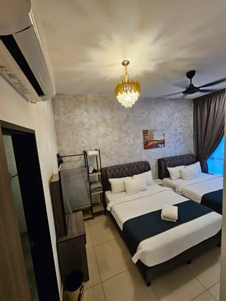 Bedroom features: two single beds with upholstered headboards, white bedding with dark blue throw blankets, chandelier light fixture, ceiling fan, wall-mounted air conditioning unit, decorative wall with textured finish, curtains in dark brown, nightstand with lamp, open shelving unit, floor tiles, framed artwork on wall; style: modern.
