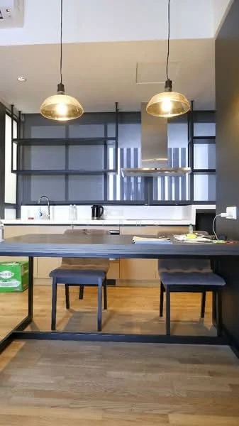 Kitchen features: wooden flooring, white cabinetry, stainless-steel range hood, built-in oven, 4-burner gas hob, single-bowl stainless-steel sink, chrome pull-down faucet, pendant lights, open shelving, kitchen island, black countertop, kettle, microwave; style: modern.