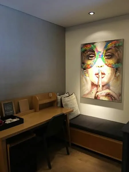 Study features: wooden desk, black chair, built-in shelving, decorative artwork on wall, grey accent wall, window seat with cushions, laminate flooring, recessed ceiling lights; style: modern.