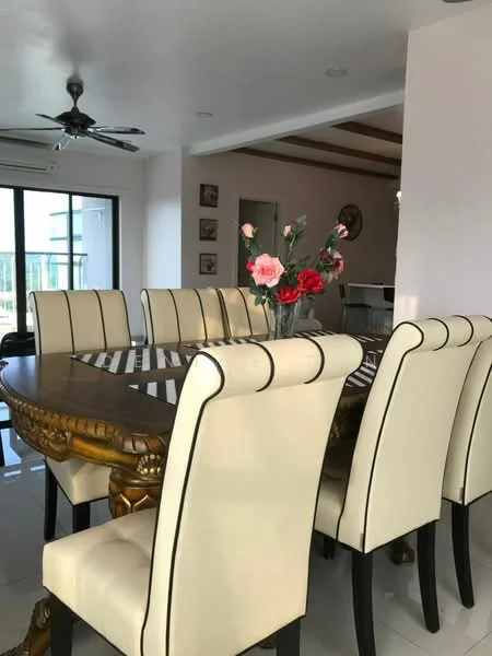 Dining features: 8-seater dining table with ornate wooden base, cream upholstered dining chairs with black stripes, decorative vase with flowers on the table, white tiled flooring, ceiling fan with light, large glass sliding door leading to balcony, recessed ceiling lights, wall-mounted artwork, open layout to adjacent living area; style: modern; view: city.