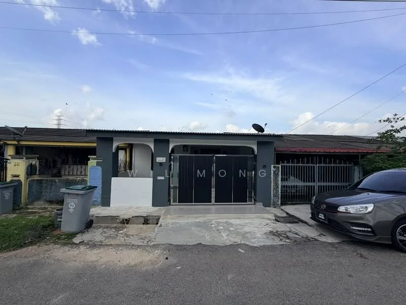 Exterior type: semi-detached house; features: grey painted facade, flat roof, metal gate, fenced perimeter, driveway with concrete surface, satellite dish on roof, manicured lawn, single-storey, parking space for one car, front porch area; style: modern.