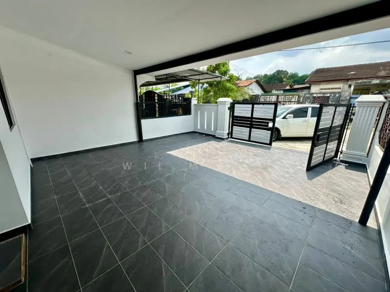 Exterior features: tiled flooring in dark grey, white painted walls, black metal gate, open car porch, surrounded by greenery, driveway with interlocking pavers, covered area with roof, fenced perimeter; style: modern.