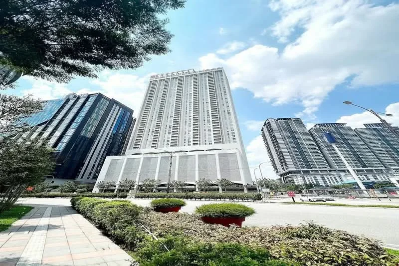 Exterior type: high-rise condominium; features: glass curtain wall, white painted facade, approximately 30-storey high-rise, manicured lawn, surrounded by mature greenery, paved walkway, urban context with nearby buildings; style: modern.