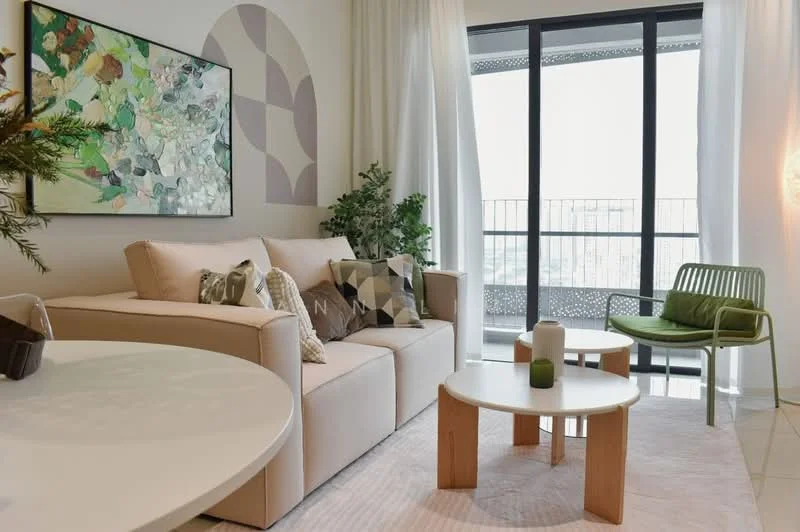 Living features: 3-seater fabric sofa in beige, decorative cushions in various colors, round white coffee table, small round wooden side table, green accent chair, framed artwork with abstract design, floor-to-ceiling windows, sheer white curtains, light-colored area rug, indoor plant, wall-mounted light fixture; style: modern; view: city.