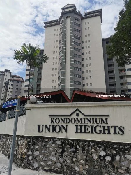 Exterior type: high-rise condominium; features: grey painted facade, balconies on upper floors, flat roof, approximately 10-storey high-rise, manicured landscaping, palm tree in foreground, stone-clad base, signage with building name, surrounded by residential buildings; style: modern.