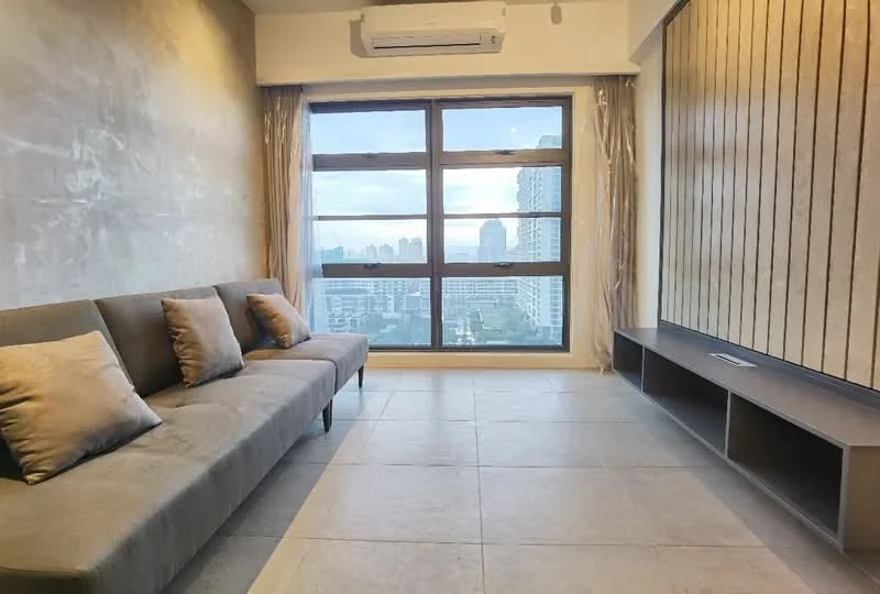 Living features: grey fabric sofa with cushions, floor-to-ceiling windows, city skyline view, light grey tiled flooring, exposed concrete wall, wood panel accent wall, curtains, wall-mounted TV console; style: modern; view: city.