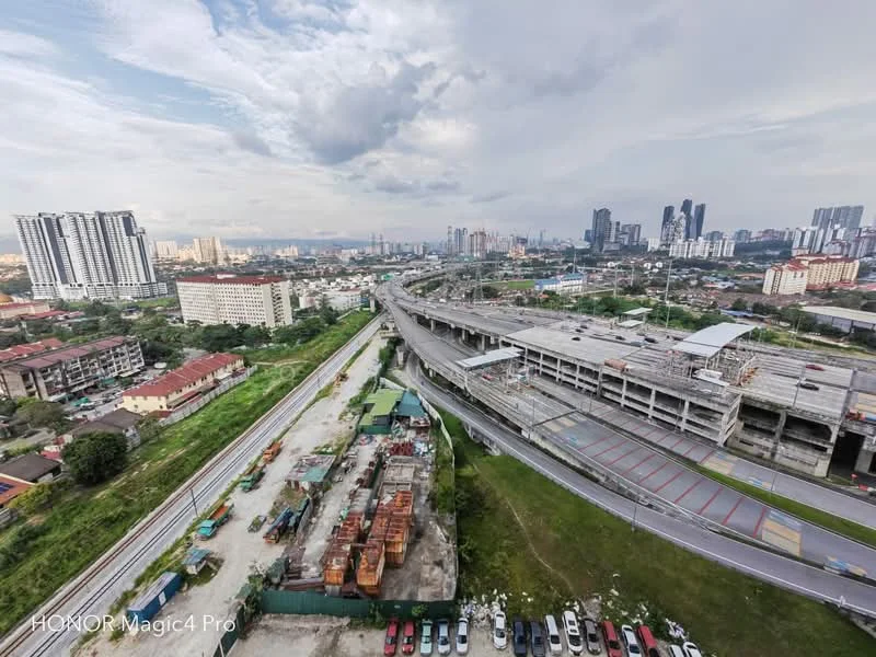 Exterior features: city skyline in background, highway visible, multi-storey car park, surrounded by greenery, urban landscape, industrial area visible; style: modern.