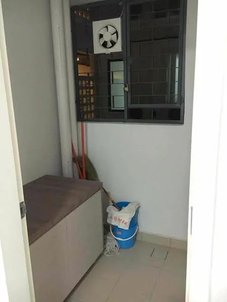 Room features: white painted walls, tile flooring, window with security grille, wall-mounted air conditioning unit, storage bench, cleaning supplies bucket, mop, broom.