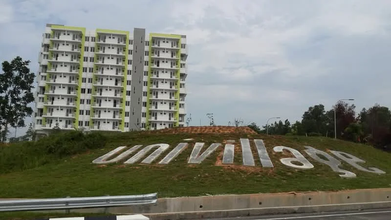 Exterior type: mid-rise condominium; features: 6-storey building, green and white facade, large signage with 'univillage', landscaped grassy area in front, surrounded by trees, urban setting, clear sky, parking area visible; style: modern.