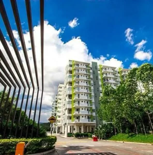 Exterior type: mid-rise condominium; features: green and white painted facade, 5-storey building, surrounded by greenery, landscaped entrance, clear blue sky, modern architectural design, balconies on upper floors, driveway leading to the building; style: modern.