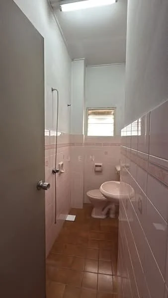 Bathroom features: white tiled walls, pink tiled walls, brown ceramic tile flooring, shower with wall-mounted faucet, toilet, window for natural light, light fixture on ceiling, towel holder.