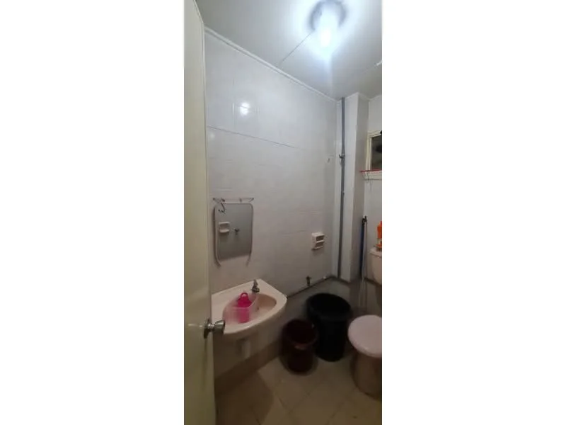 Bathroom features: white tiled walls, ceramic tile flooring, single-sink vanity with basin, toilet, mirror, shower area, plumbing fixtures, light fixture.