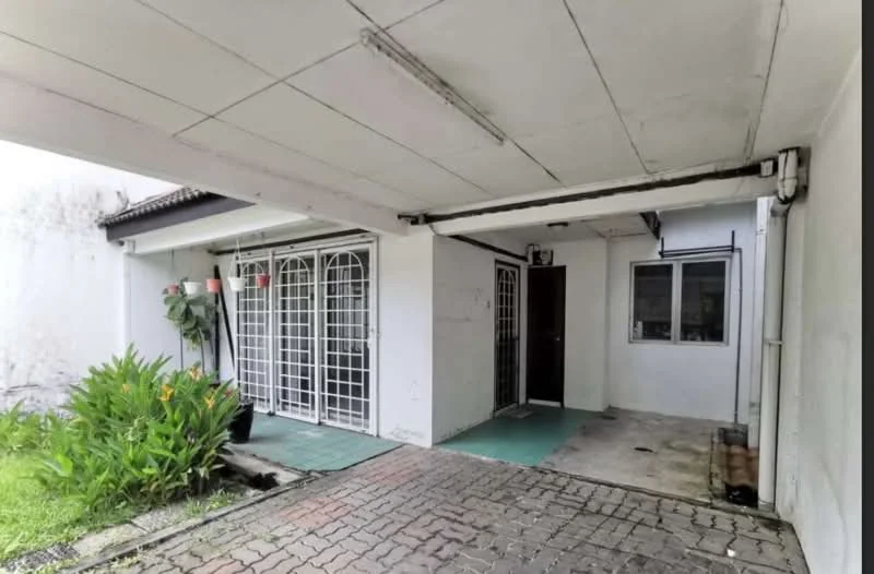 Exterior type: linked terrace house; features: paved driveway, manicured garden with shrubs, double doors with wrought iron grilles, single window with security bars, covered porch area, white painted facade, exposed concrete walls, flat roof, outdoor lighting fixtures; style: modern.