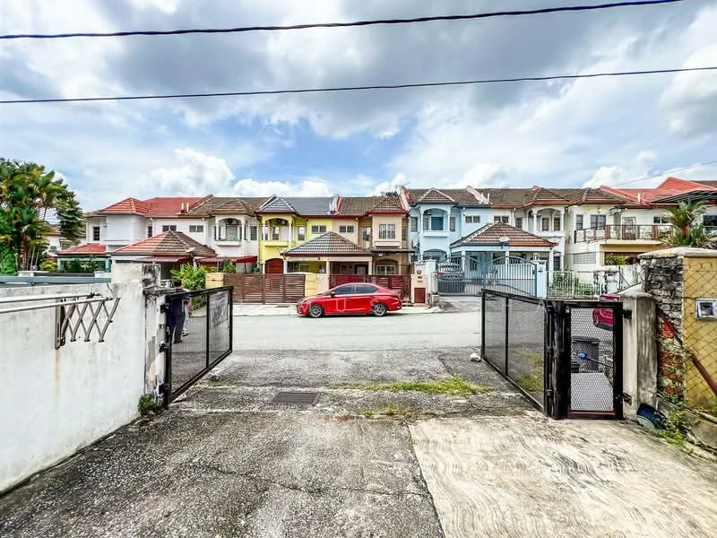 Exterior type: linked terrace house; features: gated entrance, two-storey houses, red car parked in front, manicured lawns, paved driveway, various colored facades, rooftop overhangs, front porches, fence surrounding the property, street view, clear blue sky; style: modern.