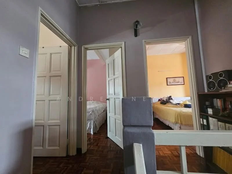 Room features: purple painted walls, wooden flooring, two doorways leading to other rooms, white ceiling, light fixture on the wall, bookshelf with decorative items, bedroom visible in the background with light-colored bedding; style: traditional.