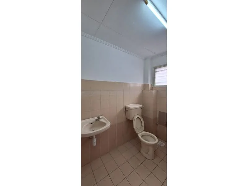 Bathroom features: white ceramic toilet, single-sink vanity with wall-mounted faucet, mirror above sink, light fixture on ceiling, beige tiled walls, beige tiled flooring, window for natural light.