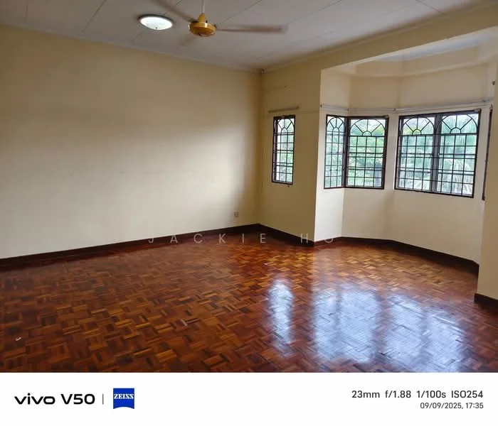 Room features: wooden flooring, cream painted walls, ceiling fan, large windows with grid pattern, natural light, corner room, high ceiling, no visible furniture; view: garden.