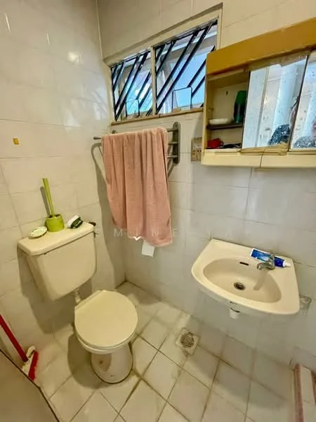 Bathroom features: white tiled walls, white tiled flooring, one-piece toilet, wall-mounted sink, mirror above sink, towel rack, window with security bars, pink towel, green toothbrush holder, soap dish.