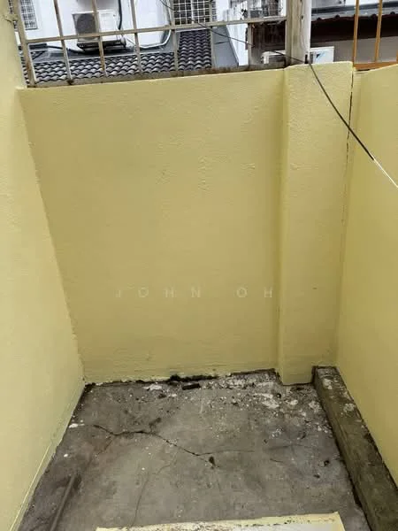 Room features: yellow painted walls, concrete flooring, exposed electrical wiring, partial wall, drainage visible on floor.