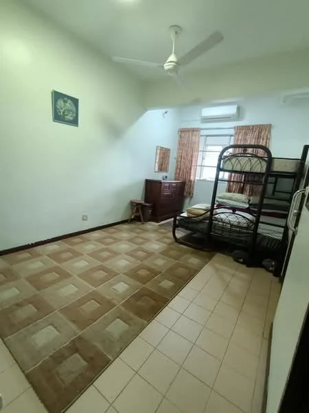 Bedroom features: bunk bed with metal frame, single mattress on top bunk, double mattress on bottom bunk, ceiling fan, wall-mounted air conditioning unit, window with sheer curtains, cream painted walls, tile flooring, area rug with geometric pattern, wooden dresser, wooden stool, framed artwork on wall.
