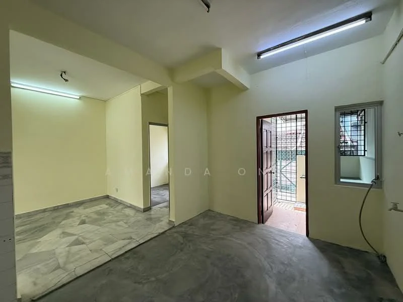 Room features: light grey marble flooring, cream painted walls, exposed ceiling with fluorescent lighting, doorway leading to outdoor area, window with metal grille, open layout, corner wall, no visible furniture; style: minimalist.