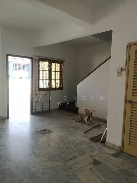 Room features: white painted walls, marble flooring, staircase, window with grid design, door leading outside, unfinished area with paint supplies, light source from window, open layout.