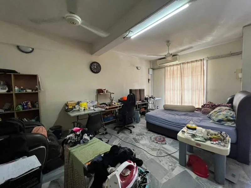 Room features: grey marble flooring, white painted walls, ceiling fan, window with vertical blinds, double bed with mattress, study desk with chair, computer monitor, bookshelf with clutter, various items on floor, wall clock, air conditioning unit, black office chair.
