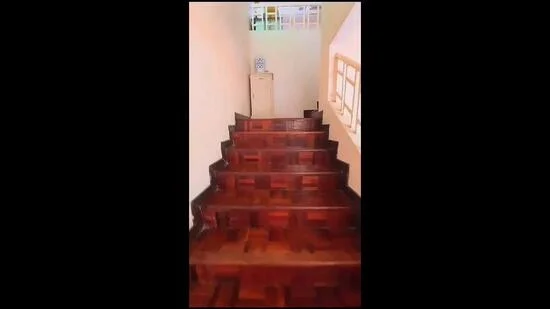 Room features: wooden staircase, parquet wood flooring, light-colored painted walls, natural light from windows, handrail, storage cabinet at the top of the stairs; style: modern.
