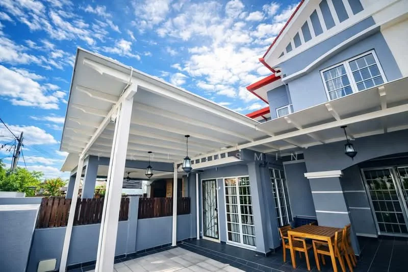 Exterior type: detached bungalow; features: grey painted facade, red pitched roof, white wooden beams, outdoor dining table, paved flooring, lantern-style outdoor lighting, fenced area, large windows, covered patio, manicured landscaping; style: modern.