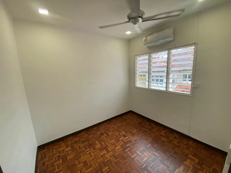 Room features: white painted walls, parquet wood flooring, 5-blade ceiling fan, 1 wall-mounted split AC, window with grid pattern, natural light from window.