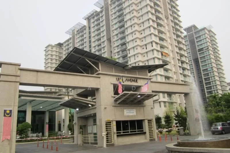 Exterior type: high-rise condominium; features: modern facade with glass and concrete, double-volume main lobby, water feature at entrance, flag poles with Malaysian flags, covered entrance with awning, surrounded by landscaped greenery, security guard house at entrance, multiple storeys visible, parking area in front; style: modern.