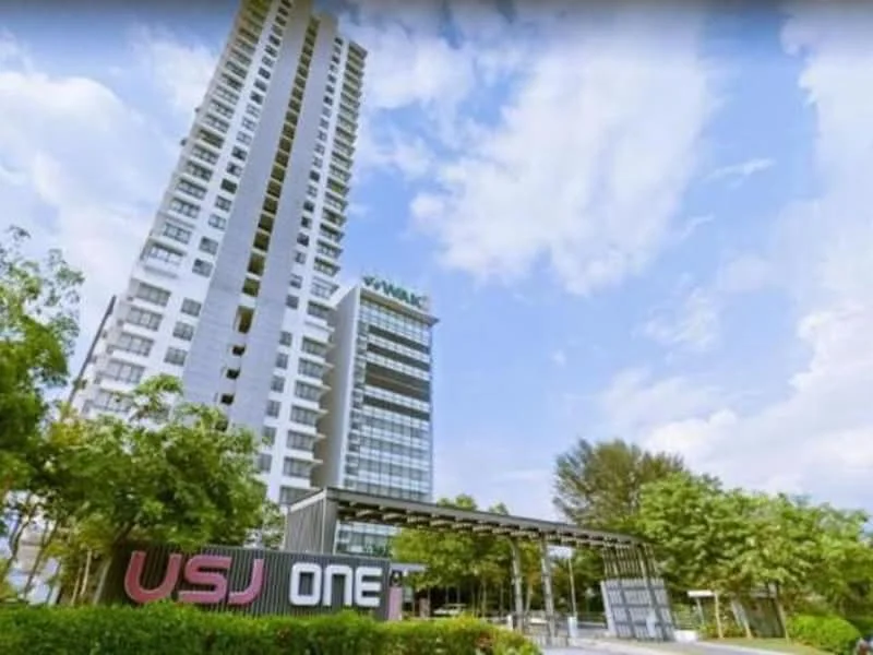 Exterior type: high-rise condominium; features: glass curtain wall, white painted facade, recessed balconies, surrounded by mature greenery, signage visible, modern architectural design, multiple storeys, landscaped entrance; style: modern.