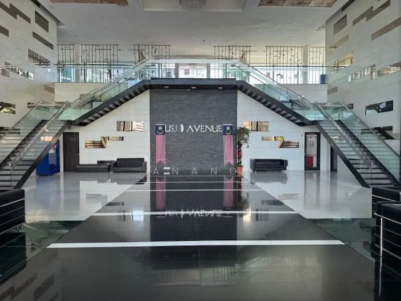 Lobby features: double-volume ceiling, marble flooring in black and white, glass railing on staircase, modern light fixtures, reception desk, seating area with black sofas, decorative wall with signage, wall-mounted artwork, large windows for natural light, elevators visible in background; style: modern.