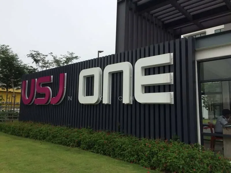 Exterior features: large signage with 'USJ ONE', modern facade, green landscaping, manicured lawn, surrounding trees, contemporary architectural elements; style: modern.