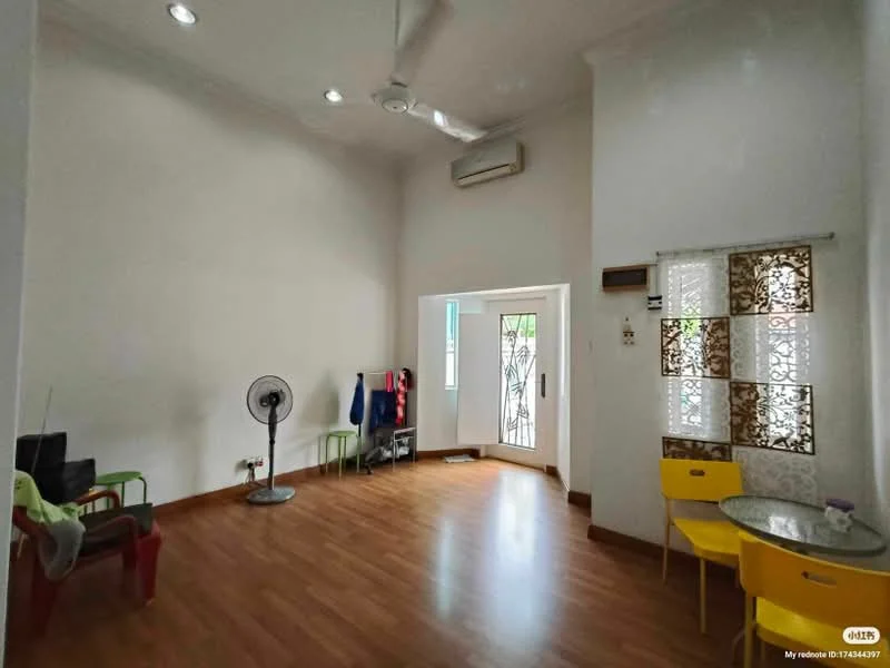 Living features: wooden flooring, white painted walls, exposed ceiling with recessed downlights, ceiling fan, large window with decorative grille, door leading to outdoor area, small round dining table with two yellow chairs, black TV console, standing fan, green and red chairs, decorative window treatments; style: modern; view: garden.