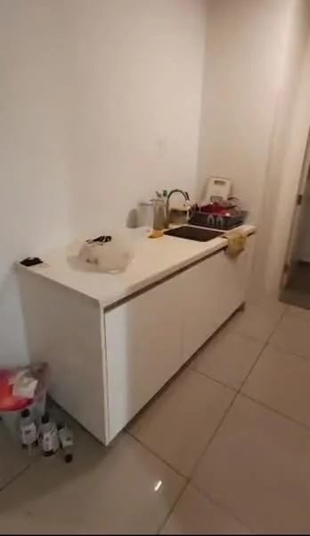 Laundry features: white cabinetry, countertop, single-bowl stainless-steel sink, chrome pull-down faucet, built-in appliances, tile flooring, white painted walls, waste bin, bottles on countertop; style: modern.