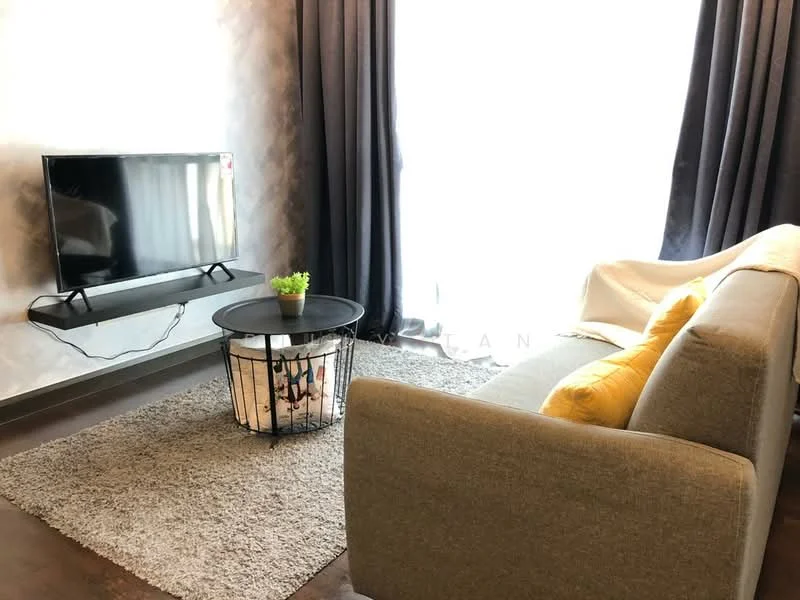 Living features: 3-seater fabric sofa in grey, yellow accent pillow, round coffee table with wire frame, area rug with neutral color, wall-mounted TV, floor-to-ceiling windows, sheer curtains, dark curtains, decorative plant on table, wooden flooring; style: modern.