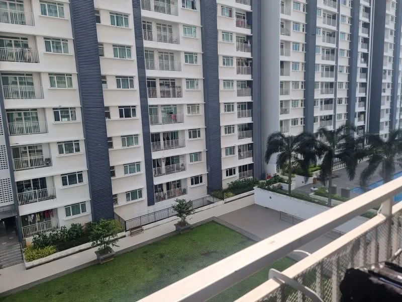 Room features: balcony with railing, view of adjacent building, green lawn area, palm trees, landscaped garden, swimming pool visible in the distance; style: modern; view: garden.